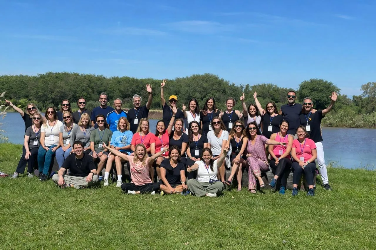 Grupo del retiro al aire libre, junto al lago, un día de sol
